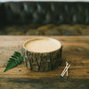 A candle in a faux bark rustic vessel